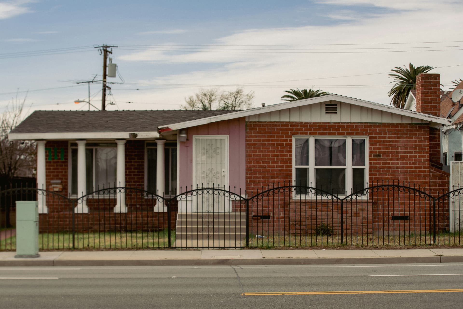 Modest single-story brick house on a residential street