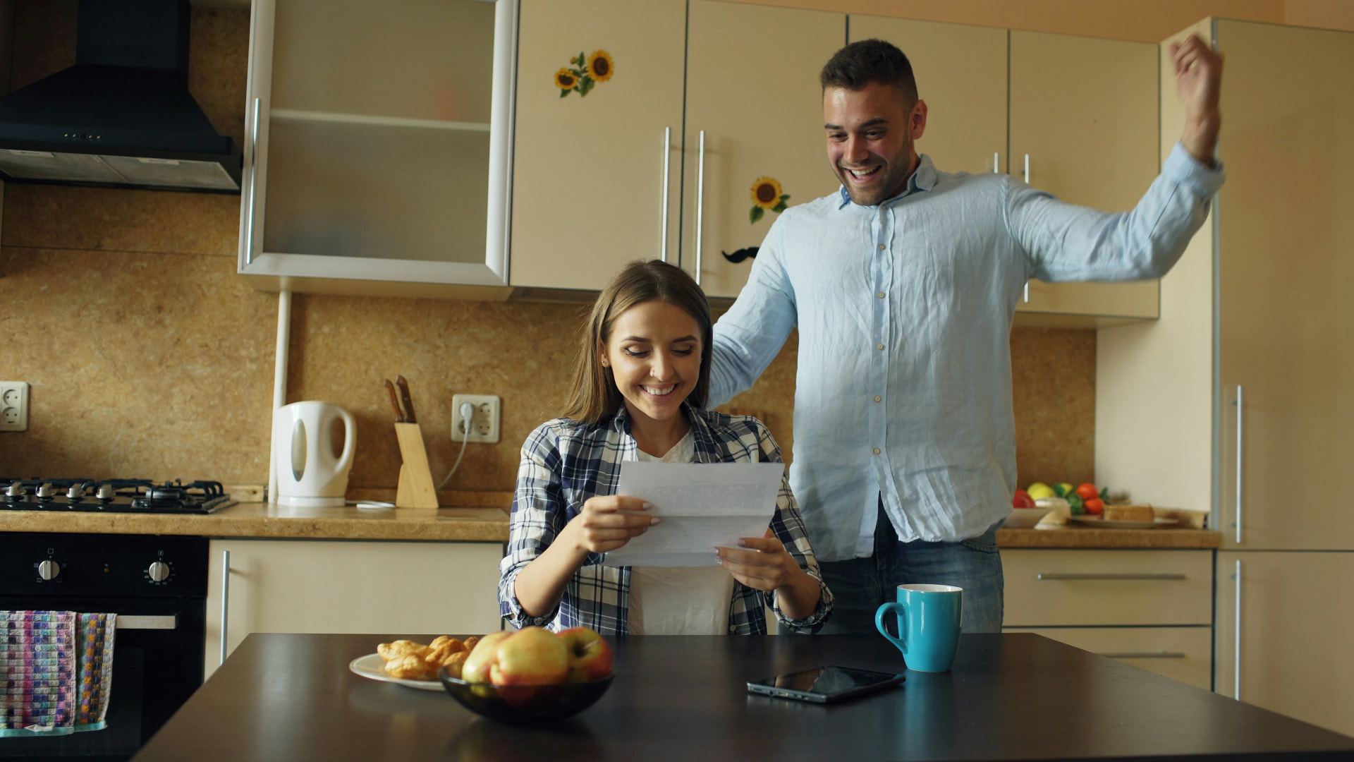 Homeowners reading a written purchase agreement at their kitchen table