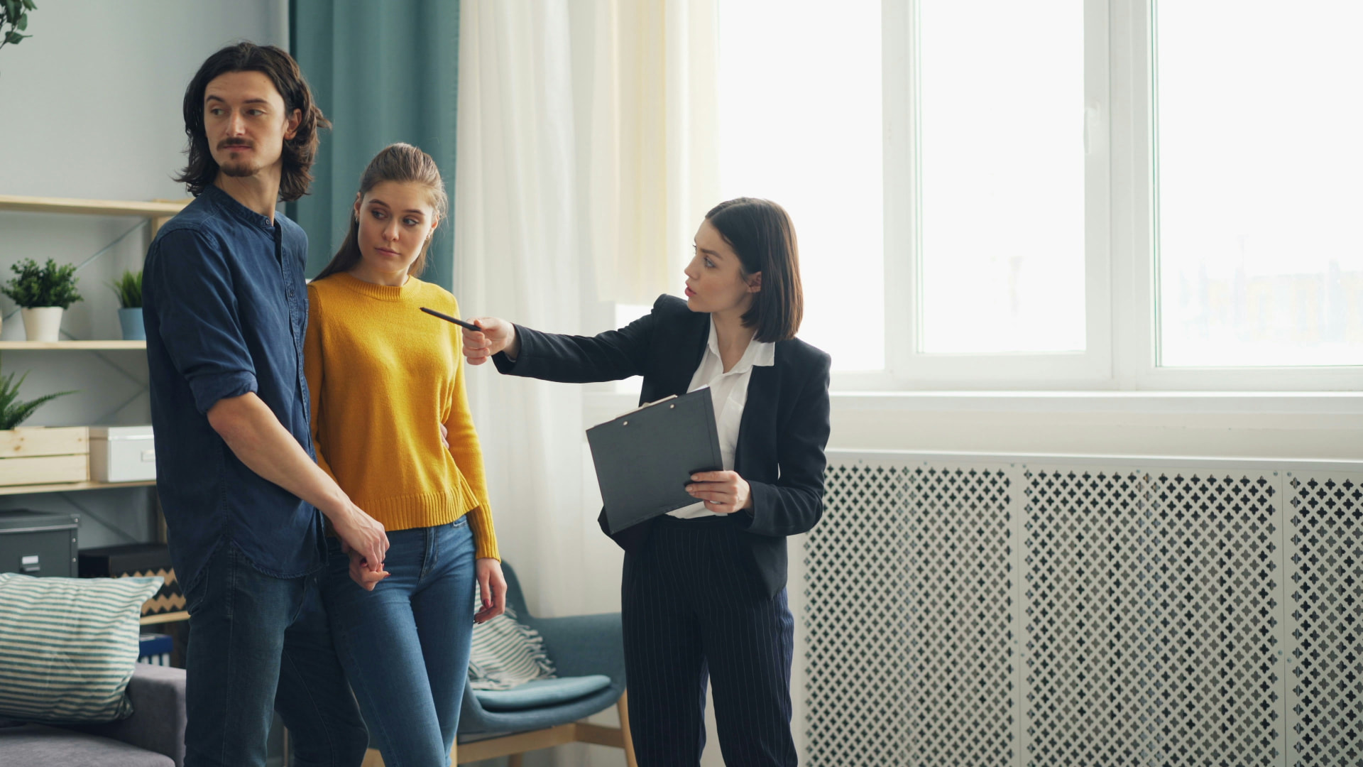 Couple listening to an agent's listing pitch in their living room